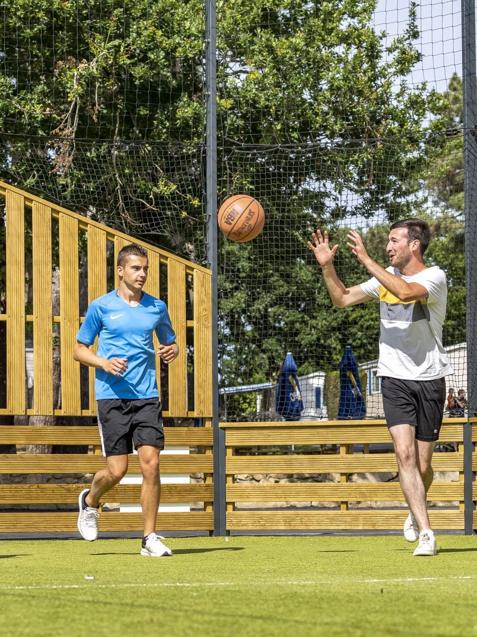 Personnes qui jouent au basket dans un camping 