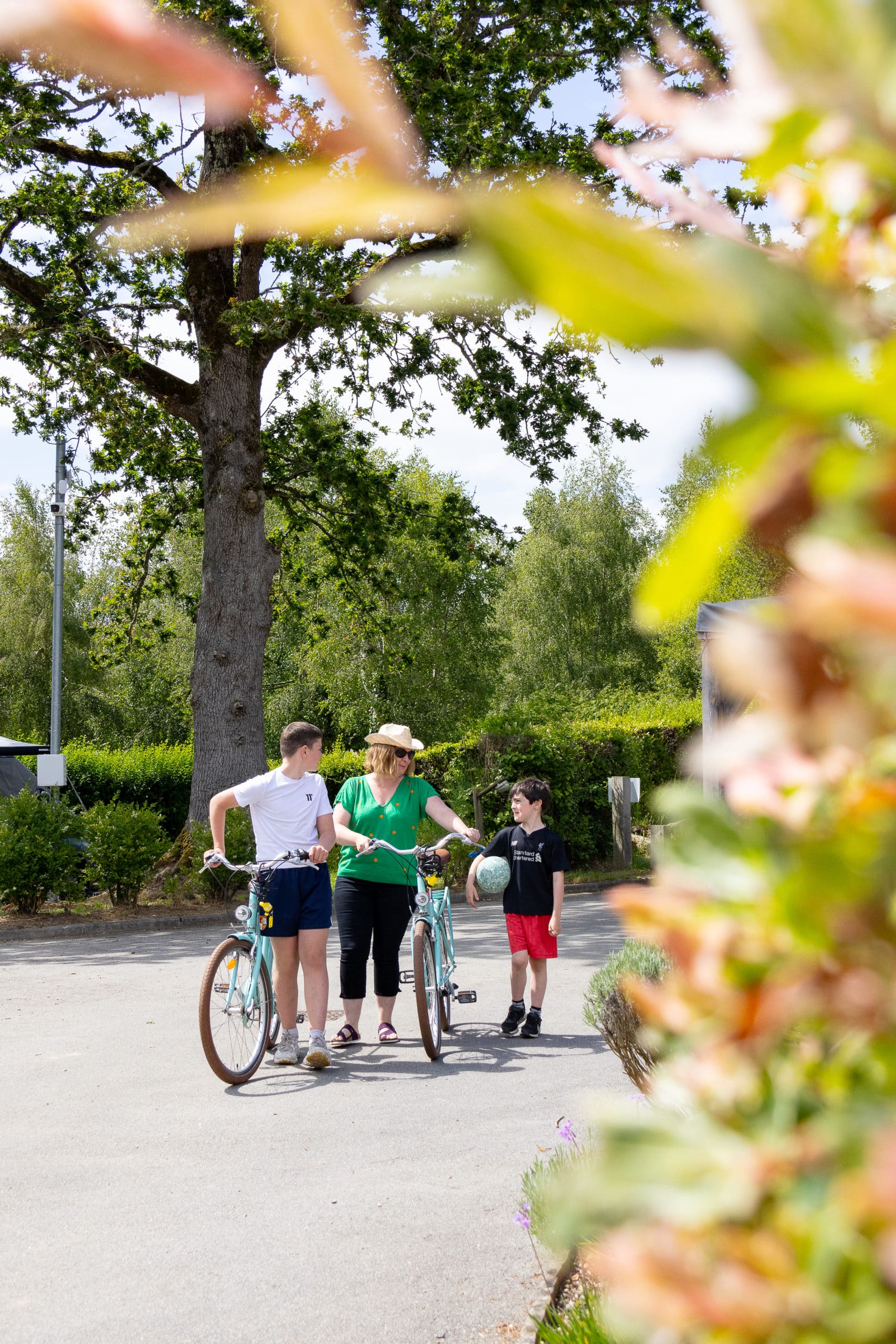 Famille avec des vélos dans les allées du camping Le Kervilor