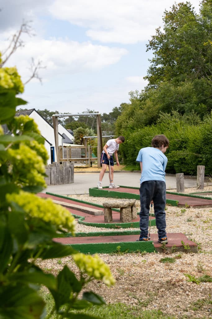 Famille qui joue au mini-golf au camping